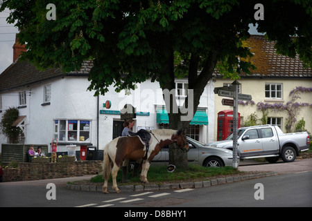 Kentisbeare village centre, Devon with ponies, village stores and post office and red telephone kiosk Stock Photo