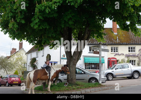 Kentisbeare village centre, Devon with ponies, village stores and post office and red telephone kiosk Stock Photo