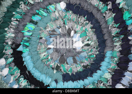A close-up of a rag rug in teal, showcasing the woven fabric texture. The image emphasizes the intricate craftsmanship of the rug and its vibrant color. Stock Photo