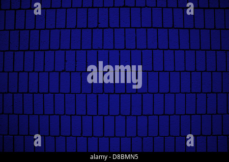 A close-up image of a royal blue brick wall featuring vertical brick orientation. The texture of the bricks is visible, showcasing the clean lines and uniform arrangement, with the bold blue color adding a striking visual appeal. Stock Photo