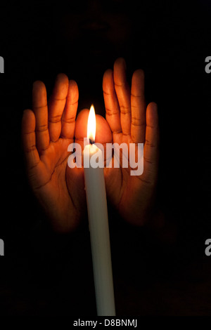 African hands cupping candlelight. Stock Photo