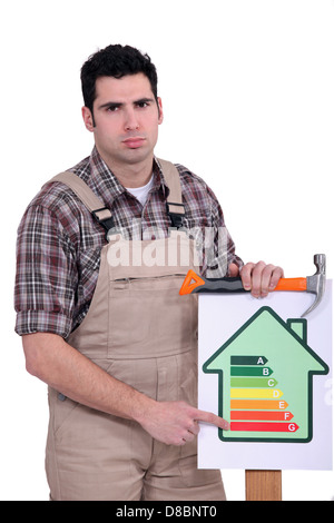 Carpenter nailing energy rating poster to wood Stock Photo