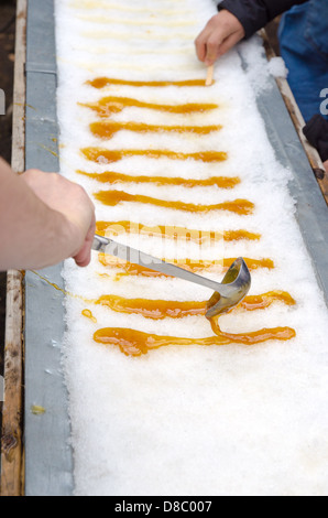 Maple taffy on snow during sugar shack period. In Quebec, Canada. Stock Photo