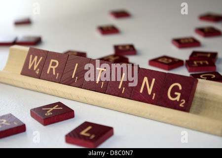 A hand holding a pen, writing on a piece of paper. The image focuses on the act of writing, emphasizing the writing process and the tools used for creation. Stock Photo