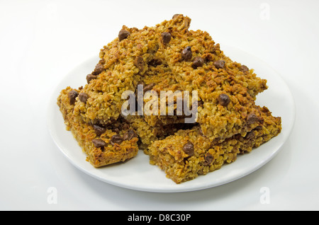 Delicious oaty chocolate flapjacks stacked on a white plate Stock Photo