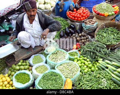 Indian street vendor selling selling fresh vegetables and fruits in farmer's market , Ahmedabad, India