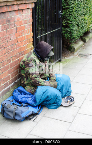 homeless man sitting down begging for money  on the Streets of Salisbury Stock Photo