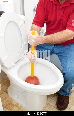 Plumber or homeowner using a plunger to unclog a toilet.  Stock Photo