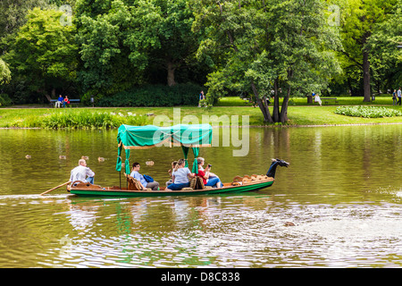 Tourists enjoy a gondola trip on the lake in Łazienki Park Łazienkowski, the largest in Warsaw. Stock Photo