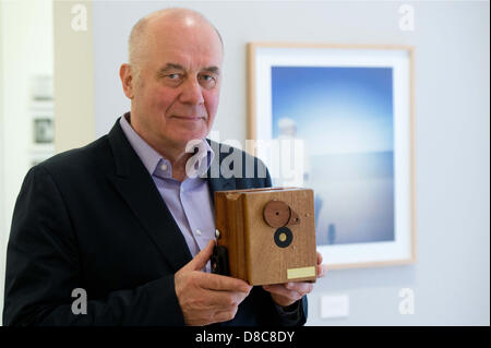 Actor Hanns Zischler stands in his exhibition holding a pin-hole camera in Berlin, Germany, 24 May 2013. The Alfred Ehrhardt Foundation is exhibiting Zischler's unusually poetic landscape pictures that he has been taking since the 1990's. Photo: MAURIZIO GAMBARINI Stock Photo