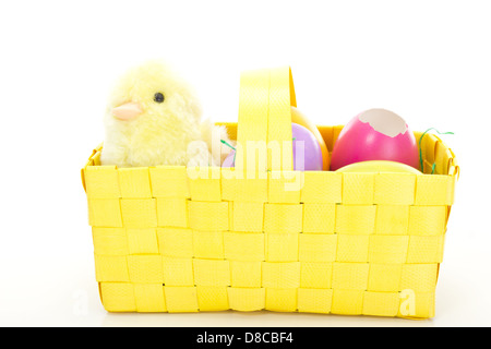 Little chick in a basket with some colorful Easter eggs Stock Photo