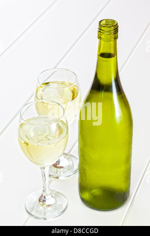 Bottle of White Wine and Glasses - bottle of chilled white wine, with two glasses of wine. Stock Photo