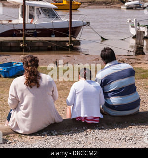 A rear view of 3 large people eating fish and chips at the harbour in Southwold , Suffolk , England , Britain , Uk Stock Photo