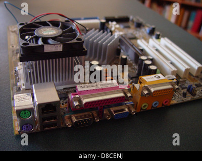 A close-up of an ATX computer motherboard with its CPU and cooling fan installed. This setup highlights the key components used in personal computing, central to the functionality of a desktop system. Stock Photo