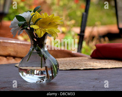 This image shows a vase filled with fresh flowers arranged on a table. The flowers, which vary in color and type, create a bright and welcoming atmosphere. Vases like these are commonly used in home decor to add vibrancy and life to a room, making them an attractive centerpiece for dining tables or side tables. Stock Photo