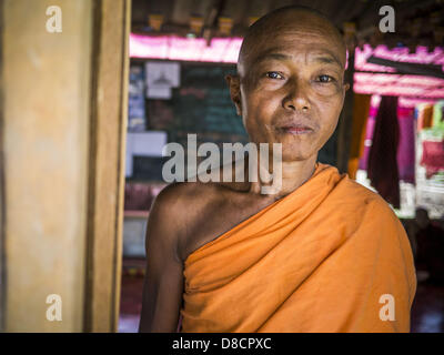 May 25, 2013 - Mae Sot, Tak, Thailand - The Abbot of a Buddhist temple in an unofficial village of Burmese refugees north of Mae Sot, Thailand. Their community is about 50 metres from the Burmese border with Thailand. About 200 people live in thatched huts spread throughout the community. They're close enough to Mae Sot that some can work in town and Burmese merchants from Mae Sot come out to their village to do business with them. The Burmese in the village don't residency papers for Thailand and are technically considered illegal immigrants. Fifty years of political turmoil in Burma (Myanmar Stock Photo