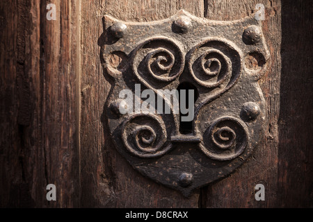 Vintage metal keyhole decorative element on weathered wooden surface Stock Photo