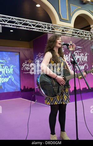 Alexandra Palace, London, UK. 25th May 2013. The first day of the Great British Tattoo Festival. Including leading tattoo artists, alternative fashion and entertainment, fans of the inked lifestyle have travelled from all over to attend. North Wales singer and Cardiff University student Eve Goodman plays acoustic guitar. Credit: Allsorts Stock Photo/Alamy Live News Stock Photo