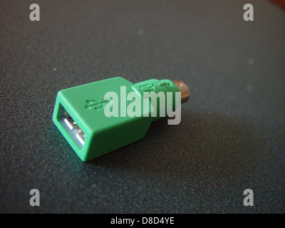 This image shows a PS 2 to USB adapter, a small device used to connect older PS2 mice to modern USB ports. The device is compact and designed for compatibility with legacy computer peripherals. Stock Photo