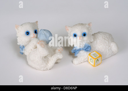 Two white kittens playing ornaments against a grey background. Stock Photo