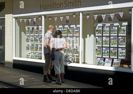 Middle aged couple looking in estate agents window Stock Photo