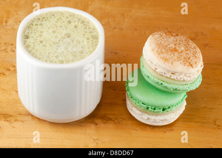 Matcha latte made with almond milk, and apple-cinnamon macarons Stock Photo