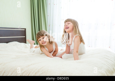 Two little girls lying on bed Stock Photo