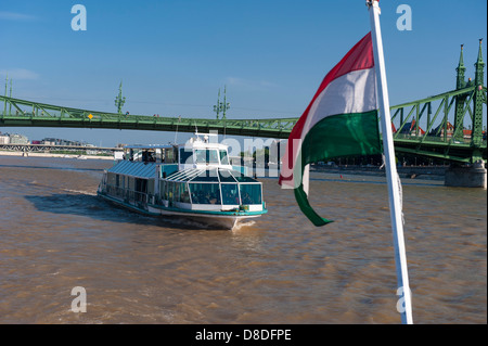 Hungary Budapest River Danube cruise ship view Liberty Freedom Bridge Szabadsag Hid Hungarian National flag blue sky sun Stock Photo