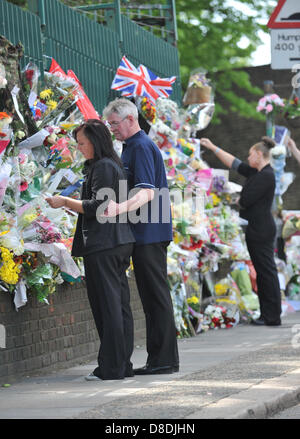 Woolwich, London, UK. 26th May 2013. Members of the family of Drummer Lee Rigby look at flowers and cards left at the scene of his murder. The family of Drummer Lee Rigby attend the scene of his murder outside Woolwich Barracks.Credit: Matthew Chattle/Alamy Live News Stock Photo