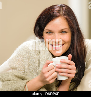 Portrait of joyful woman drinking hot beverage at home Stock Photo