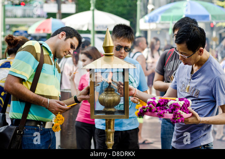 Devotees light candles at Erawan shrine, Bangkok. Stock Photo