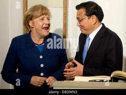 Berlin, Germany. 26th May, 2013. German Chancellor Angela Merkel (L) and China's prime minister Li Keqiang (R) share a laugh after Li Keqiang signed the guest book on his arrival for a dinner at the German government's Meseberg Palace in Meseberg some 60 km north of Berlin on May 26, 2013. China's Premier Li Keqiang met German Chancellor Angela Merkel as the close economic partners seek to weather a brewing trade spat between Beijing and the EU and forge deeper ties. Photo: Odd Andersen dpa/Alamy Live News Stock Photo