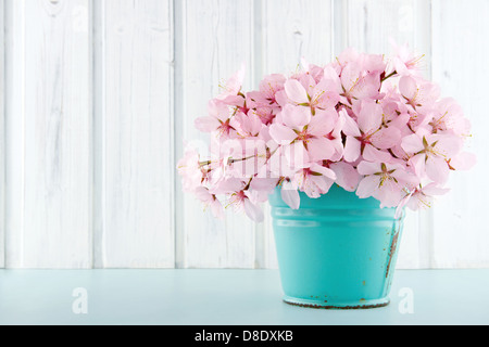 Pink cherry blossom flower bouquet on light blue vintage and white wooden background Stock Photo