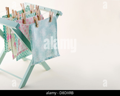 Closeup of pastel color laundry drying on vintage wooden drying rack with copy space Stock Photo