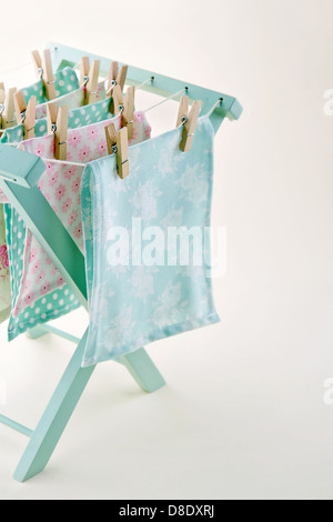 Closeup of pastel color laundry drying on vintage wooden drying rack with copy space Stock Photo