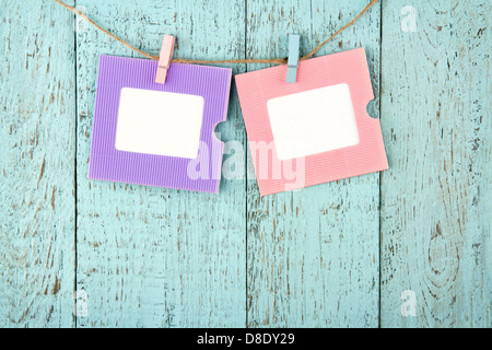Five empty colorful photo frames or notes paper hanging with clothespins on wooden blue vintage shabby chic background Stock Photo