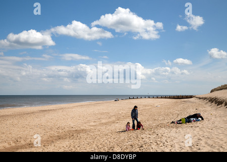 A family sitting on the sand on deserted Horsey Beach, Norfolk, East anglia England UK Stock Photo