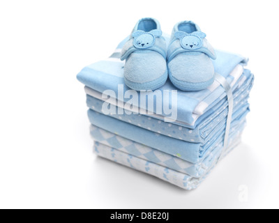 Cute blue baby boy shoes on a pile of swaddling blankets isolated on white background Stock Photo