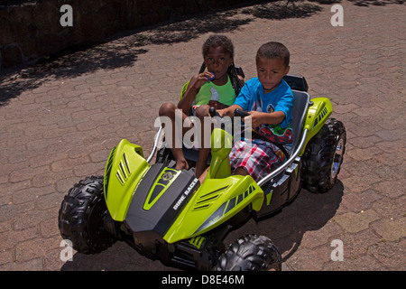 Little African American boy and girl riding a electrical go-cart, Finley Park, Santa Rosa, California, USA, North America Stock Photo