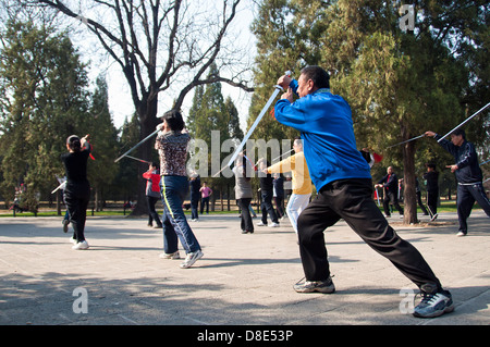 Locals practice tai chi with swords in the Temple of Heaven park, Beijing Stock Photo