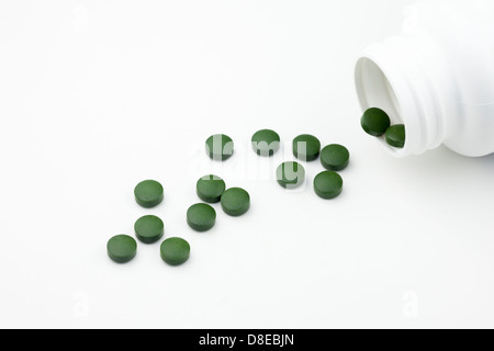 Chlorella tablets (broken wall single cell green algae) with generic bottle on white background Stock Photo