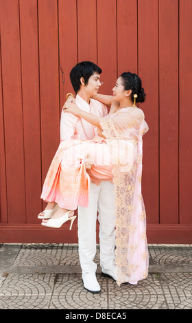 Asian Thai groom is carrying his bride in smiling face. Stock Photo