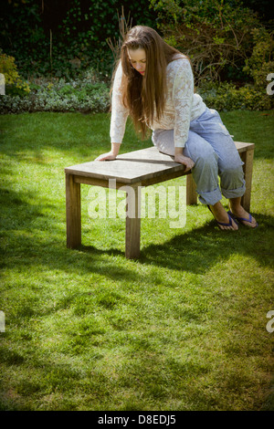 Woman Sitting on Garden Bench Stock Photo