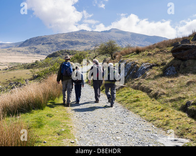 Walkers walking on Rhyd Ddu path up to Mt Snowdon with a view to peak in distance in Snowdonia, North Wales, UK, Britain Stock Photo