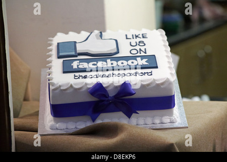 Like us on Facebook iced cake in shop window of thecakeshopoxford at Oxford, Oxfordshire UK  in May Stock Photo