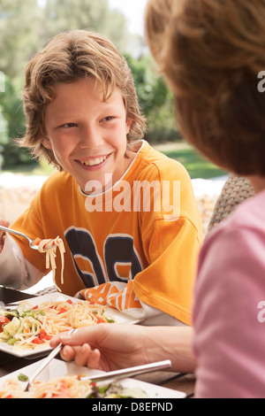 Mother and daughter eating pasta together alfresco Stock Photo