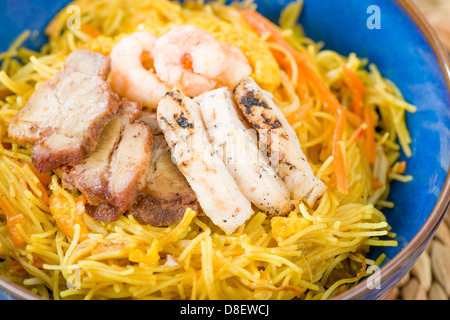 Singapore-Style Noodles - Stir-fried rice vermicelli with curry powder, topped with of chicken, char siu pork, eggs and prawns. Stock Photo