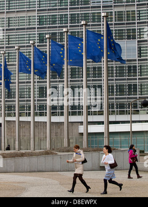 Two women running from the Berlaymont building of the European Commission in Brussels, Belgium Stock Photo