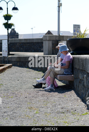 elderly couple sat on a bench Stock Photo