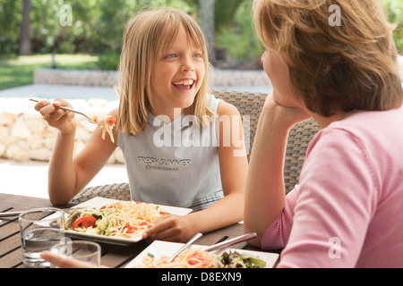 Mother and daughter eating pasta together alfresco Stock Photo